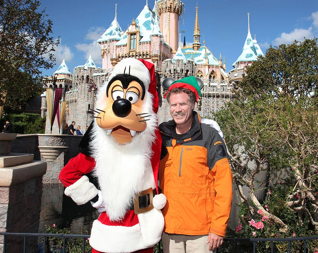 ANAHEIM, CA - NOVEMBER 09:  In this handout image provided by Disney Parks, actor Will Ferrell, star of the popular holiday film "Elf," dons a Mickey Mouse-inspired Elf hat and poses with Santa Goofy in front of the holiday-themed Sleeping Beauty Castle November 9, 2012 at Disneyland Park in Anaheim, California.  (Photo by Paul Hiffmeyer/Disney Parks via Getty Images)