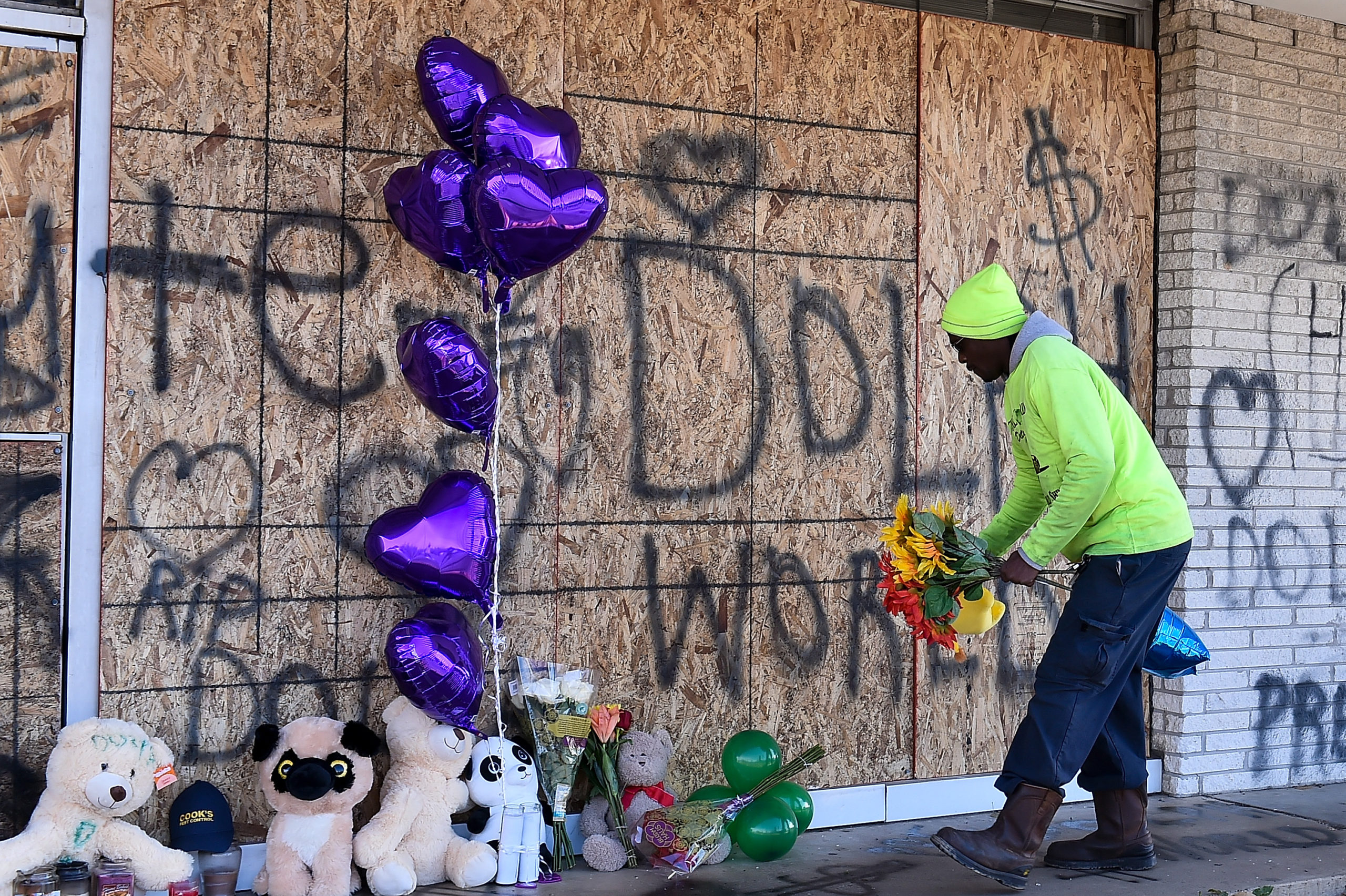 MEMPHIS, TENNESSEE - NOVEMBER 18: A man places flowers  at the memorial for Young Dolph outside of Makeda's Cookies bakery on November 18, 2021 in Memphis, Tennessee. Rapper Young Dolph, born as Adolph Thorton Jr., was killed at the age of 36 in a shooting at Makeda's Cookies bakery on November 17th in Memphis. (Photo by Justin Ford/Getty Images)