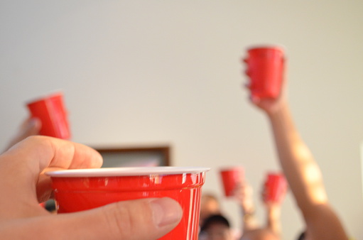 People toasting using red party cups.