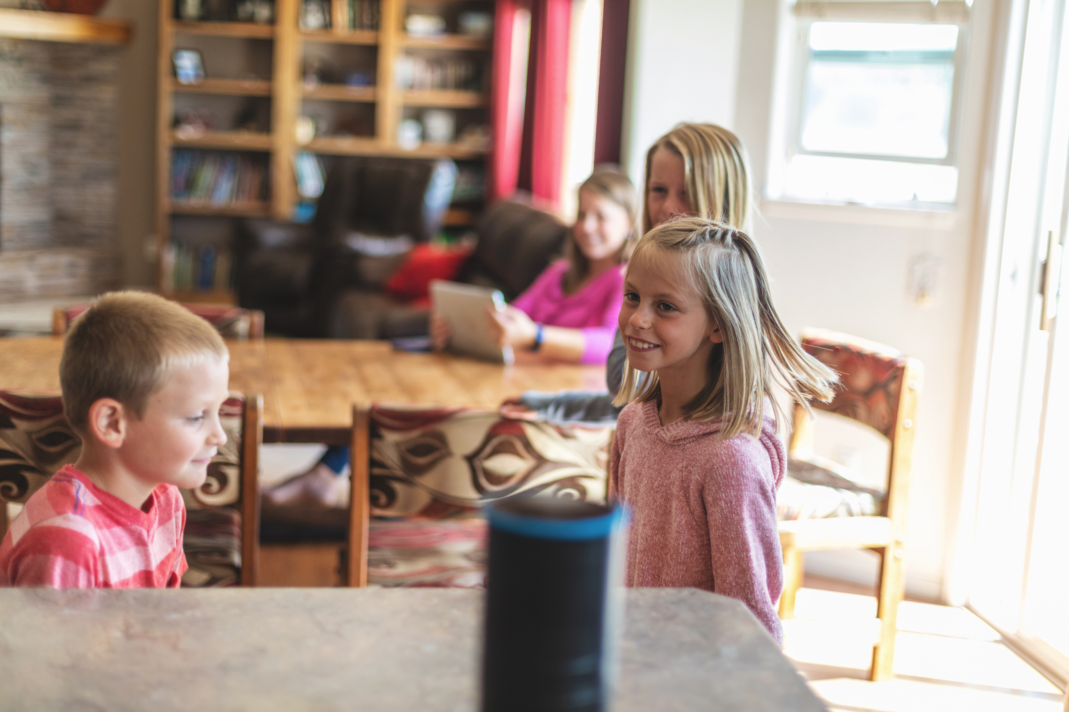 Young Millennial Mother and Children Operating Smart Device Speaker at Home Secure in Western Colorado