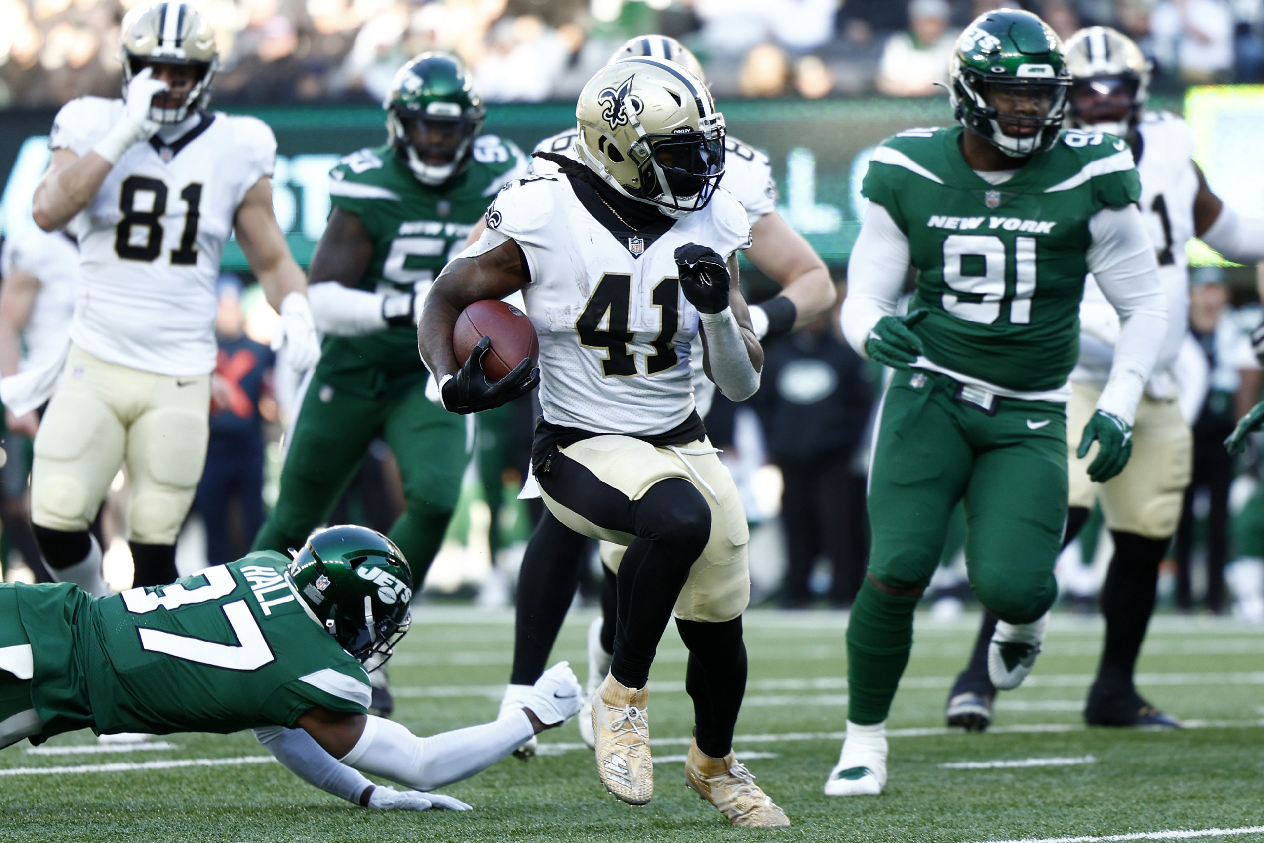 EAST RUTHERFORD, NEW JERSEY - DECEMBER 12: Alvin Kamara #41 of the New Orleans Saints runs with the ball on his way to a rushing touchdown past Bryce Hall #37 of the New York Jets in the second quarter at MetLife Stadium on December 12, 2021 in East Rutherford, New Jersey. (Photo by Sarah Stier/Getty Images)