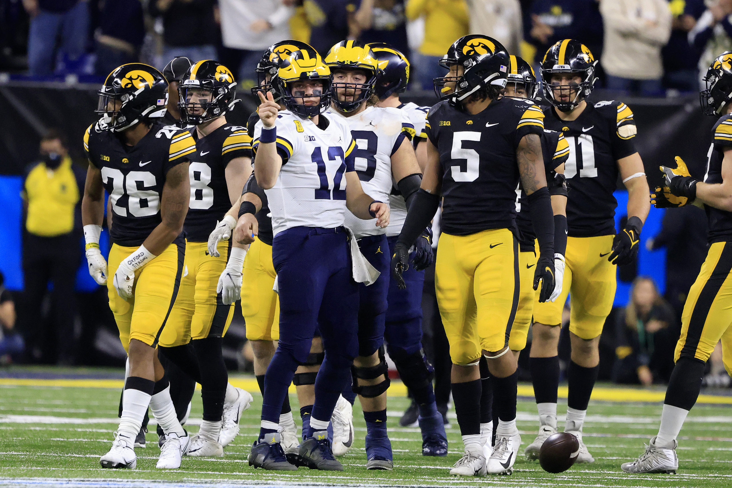 INDIANAPOLIS, INDIANA - DECEMBER 04: Cade McNamara #12 of the Michigan Wolverines reacts after a first down during the Big Ten Football Championship against the Iowa Hawkeyes at Lucas Oil Stadium on December 04, 2021 in Indianapolis, Indiana. (Photo by Justin Casterline/Getty Images)