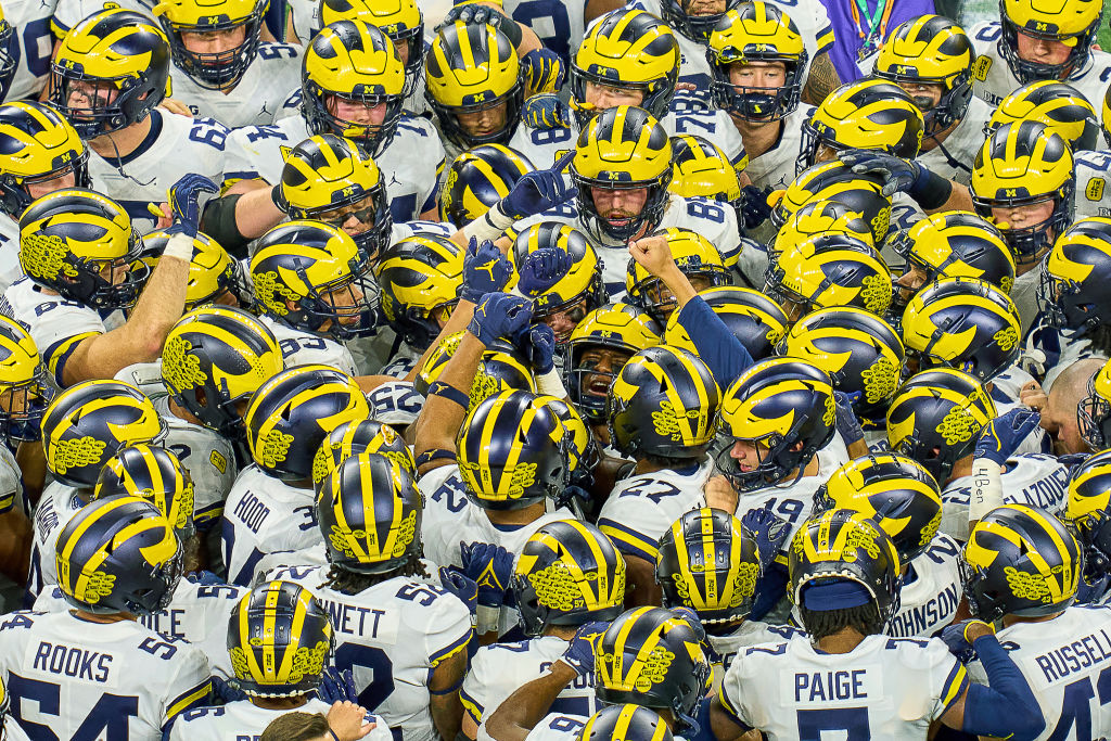 INDIANAPOLIS, IN - DECEMBER 04: Michigan Wolverines players gather in a team huddle prior to the start of the Big Ten Championship Game between the Iowa Hawkeyes and the Michigan Wolverines on December 04, 2021, at Lucas Oil Stadium, in Indianapolis, IL. (Photo by Robin Alam/Icon Sportswire via Getty Images)