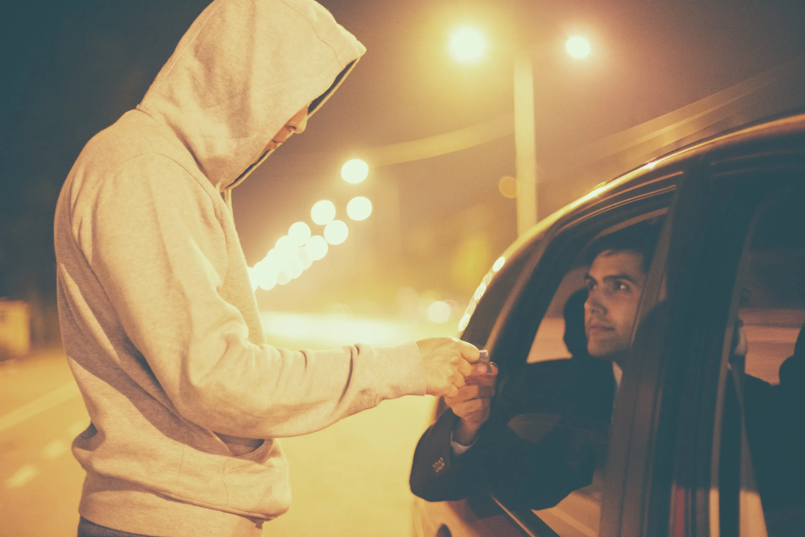 Drug Sale,Pusher brings drugs to the car window to make his sale.