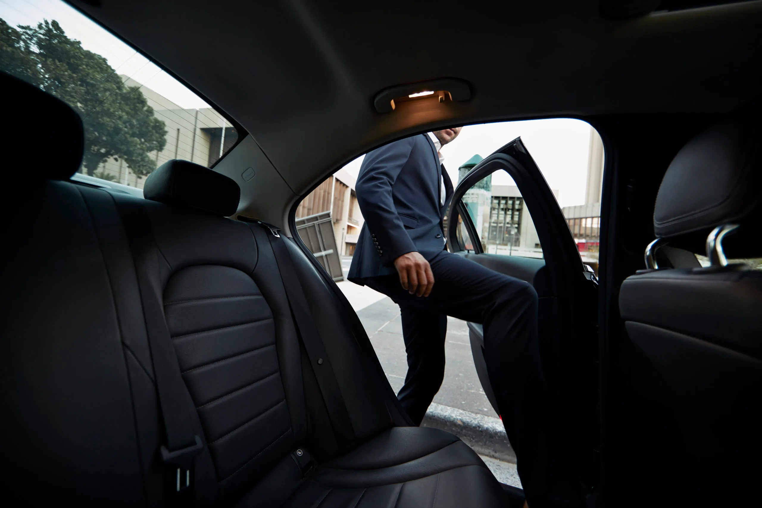 Businessman getting into backseat of exclusive cab