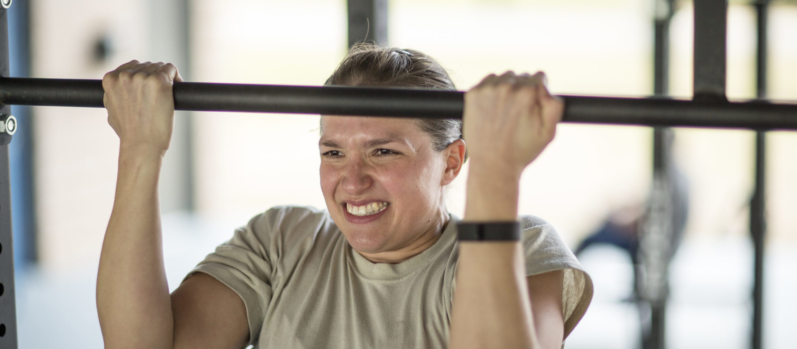 Determined female soldier doing pull ups at military air force base