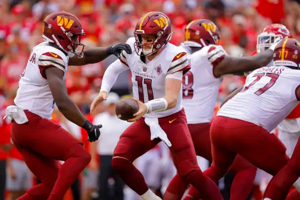 KANSAS CITY, MO - AUGUST 20: Carson Wentz #11 of the Washington Commanders hands the football to Brian Robinson #8 of the Washington Commanders during the first quarter of a preseason game against the Kansas City Chiefs at Arrowhead Stadium on August 20, 2022 in Kansas City, Missouri. (Photo by David Eulitt/Getty Images)