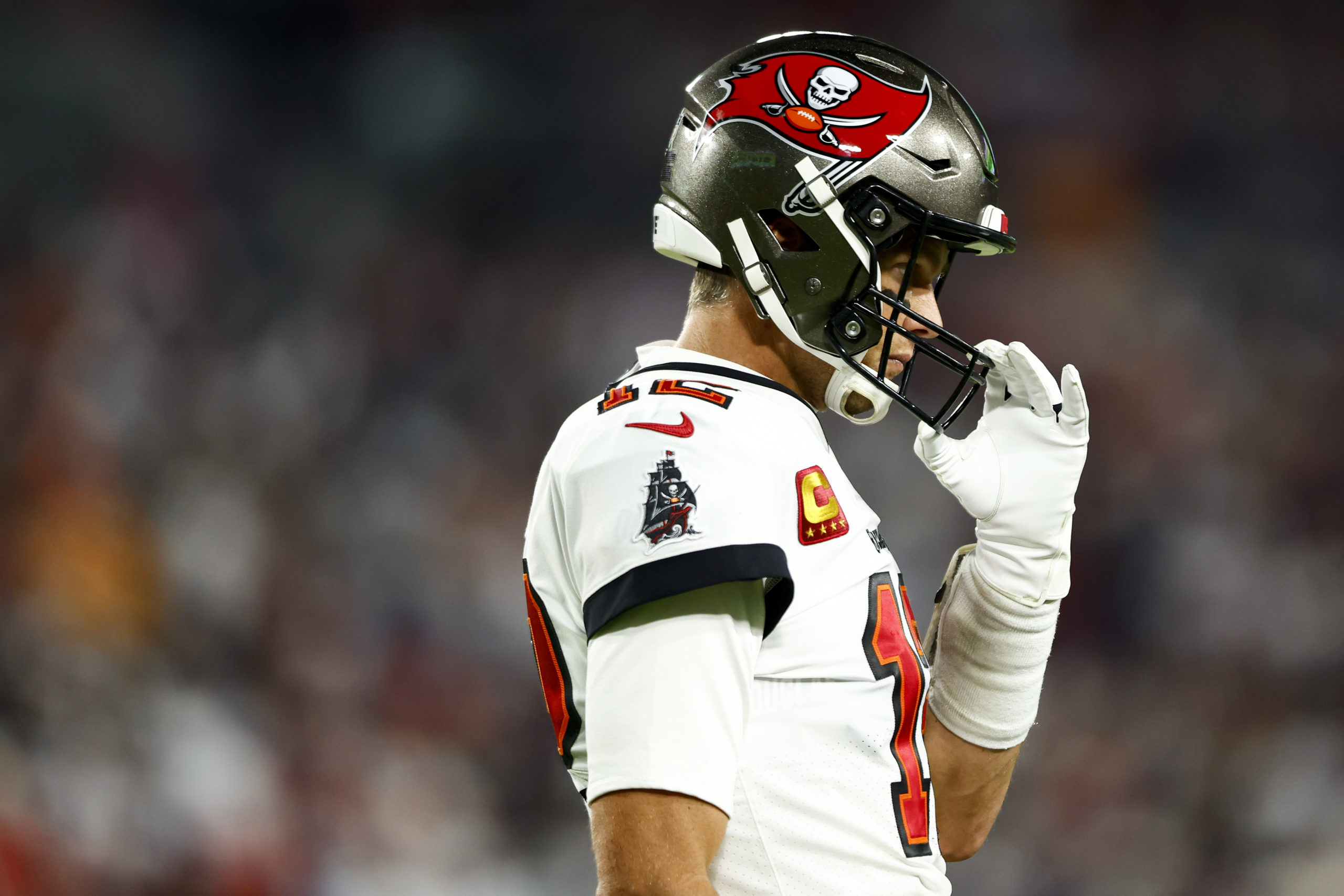 TAMPA, FL - JANUARY 16: Tom Brady #12 of the Tampa Bay Buccaneers adjusts his helmet during the third quarter of an NFL wild card playoff football game against the Dallas Cowboys at Raymond James Stadium on January 16, 2023 in Tampa, Florida. (Photo by Kevin Sabitus/Getty Images)