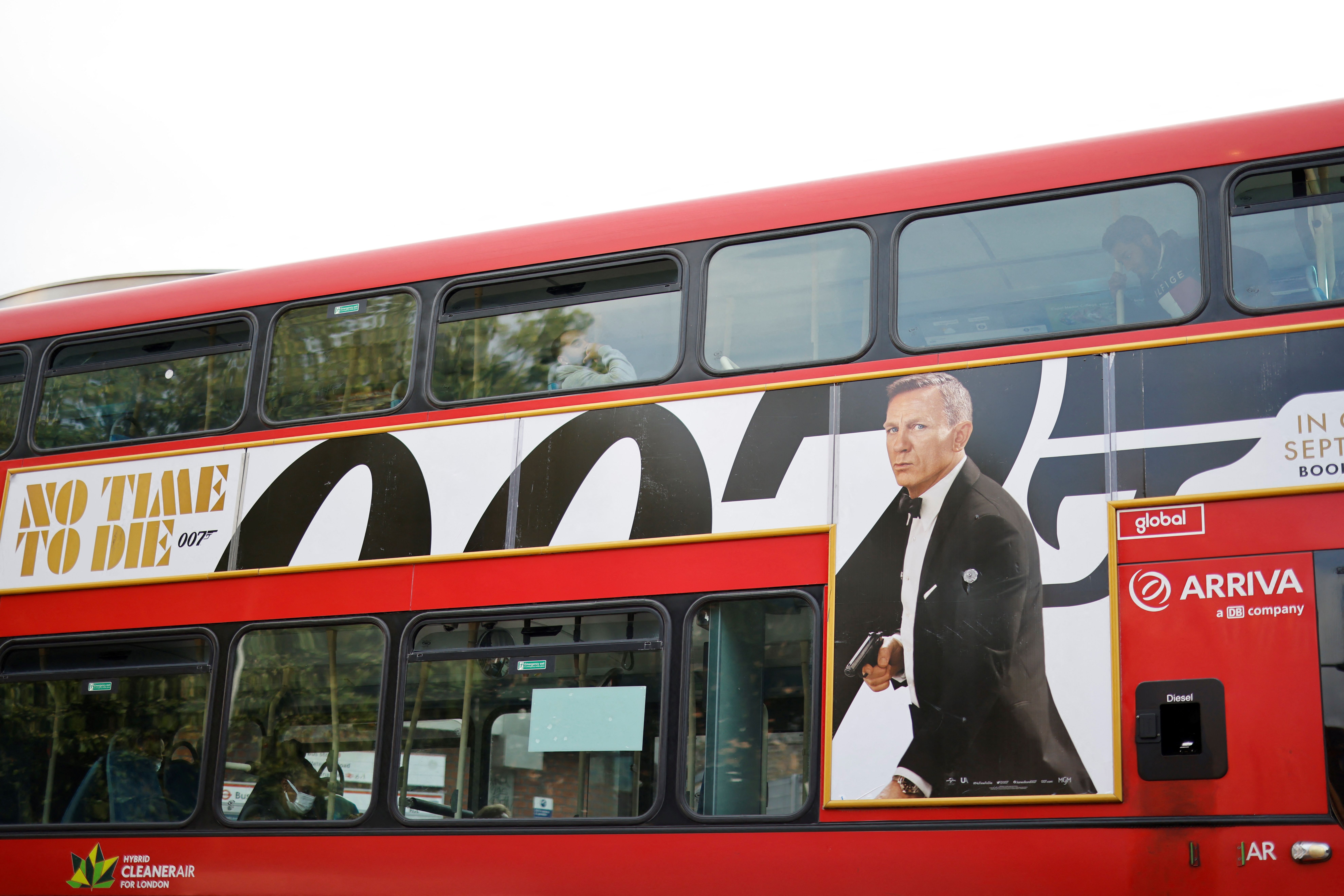A London red bus goes past a street with a poster of the latest James Bond film "No Time To Die" in London on October 4, 2021. (Photo by Tolga Akmen / AFP) (Photo by TOLGA AKMEN/AFP via Getty Images)