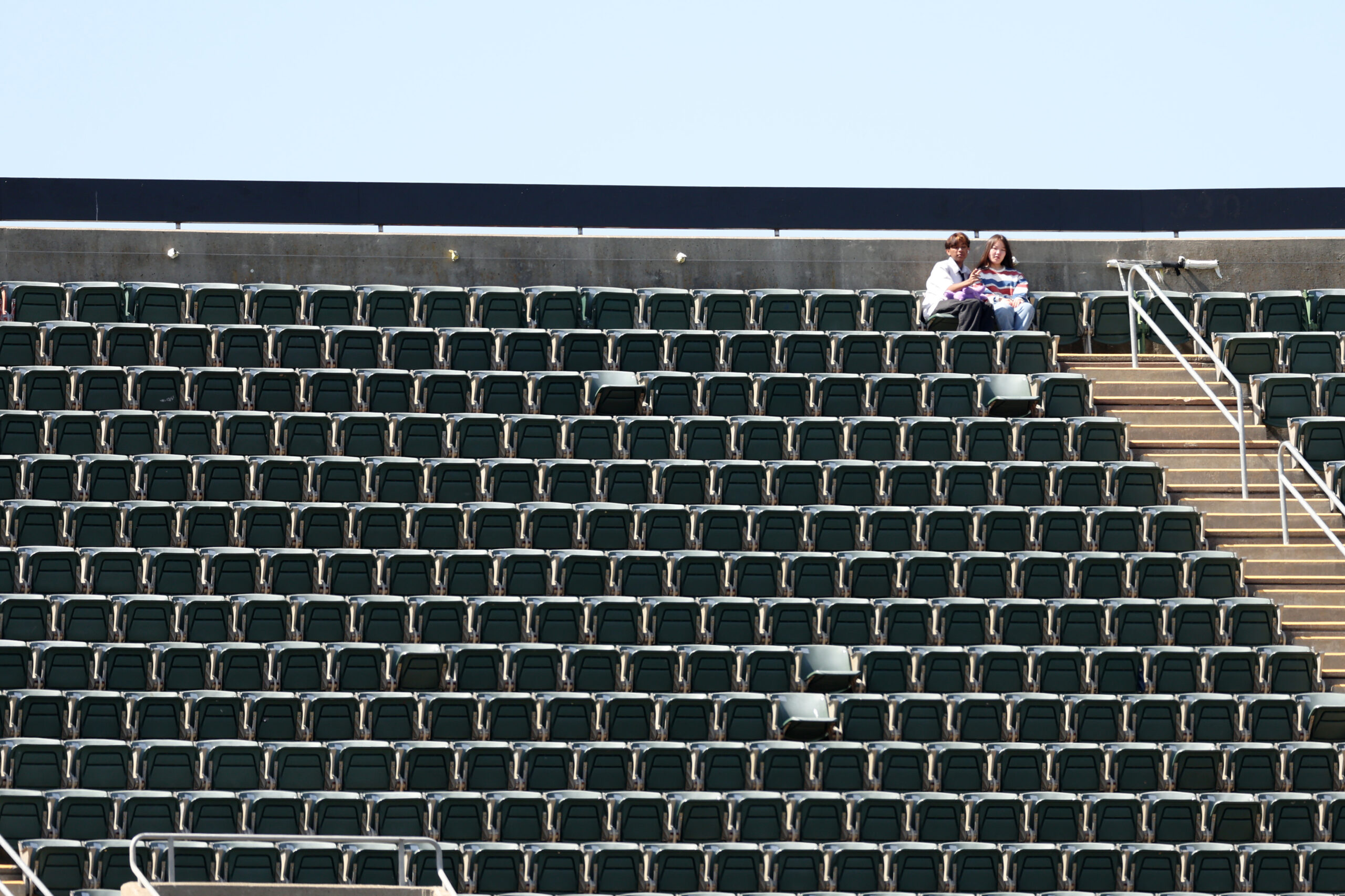OAKLAND, CALIFORNIA - APRIL 19: Fans sit in the top row of the stadium by themselves to watch the Oakland Athletics play the Chicago Cubs at RingCentral Coliseum on April 19, 2023 in Oakland, California. (Photo by Ezra Shaw/Getty Images)