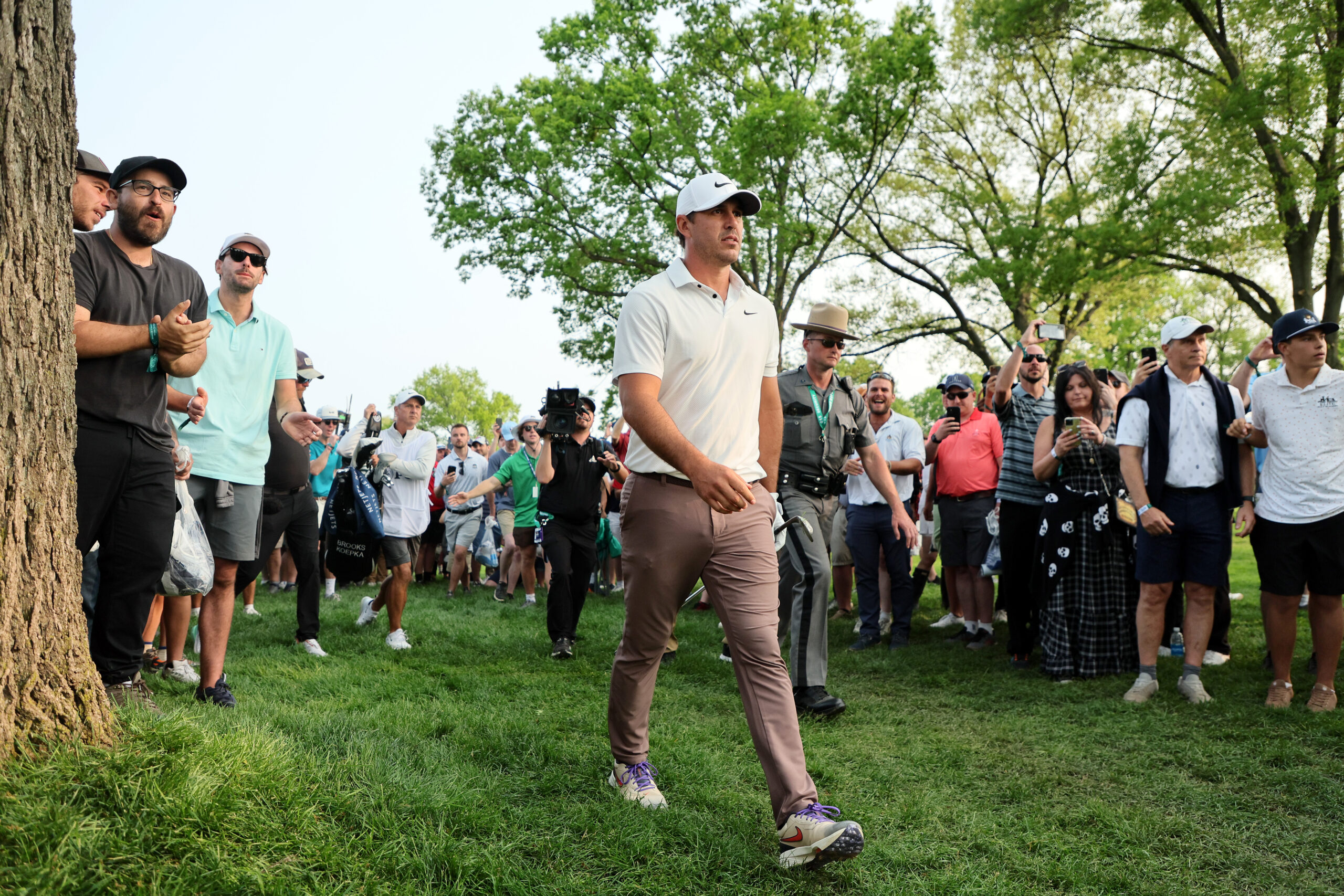 ROCHESTER, NEW YORK - MAY 21: Brooks Koepka of the United States plays a second shot on the 17th hole as fans look on during the final round of the 2023 PGA Championship at Oak Hill Country Club on May 21, 2023 in Rochester, New York. (Photo by Andy Lyons/Getty Images)