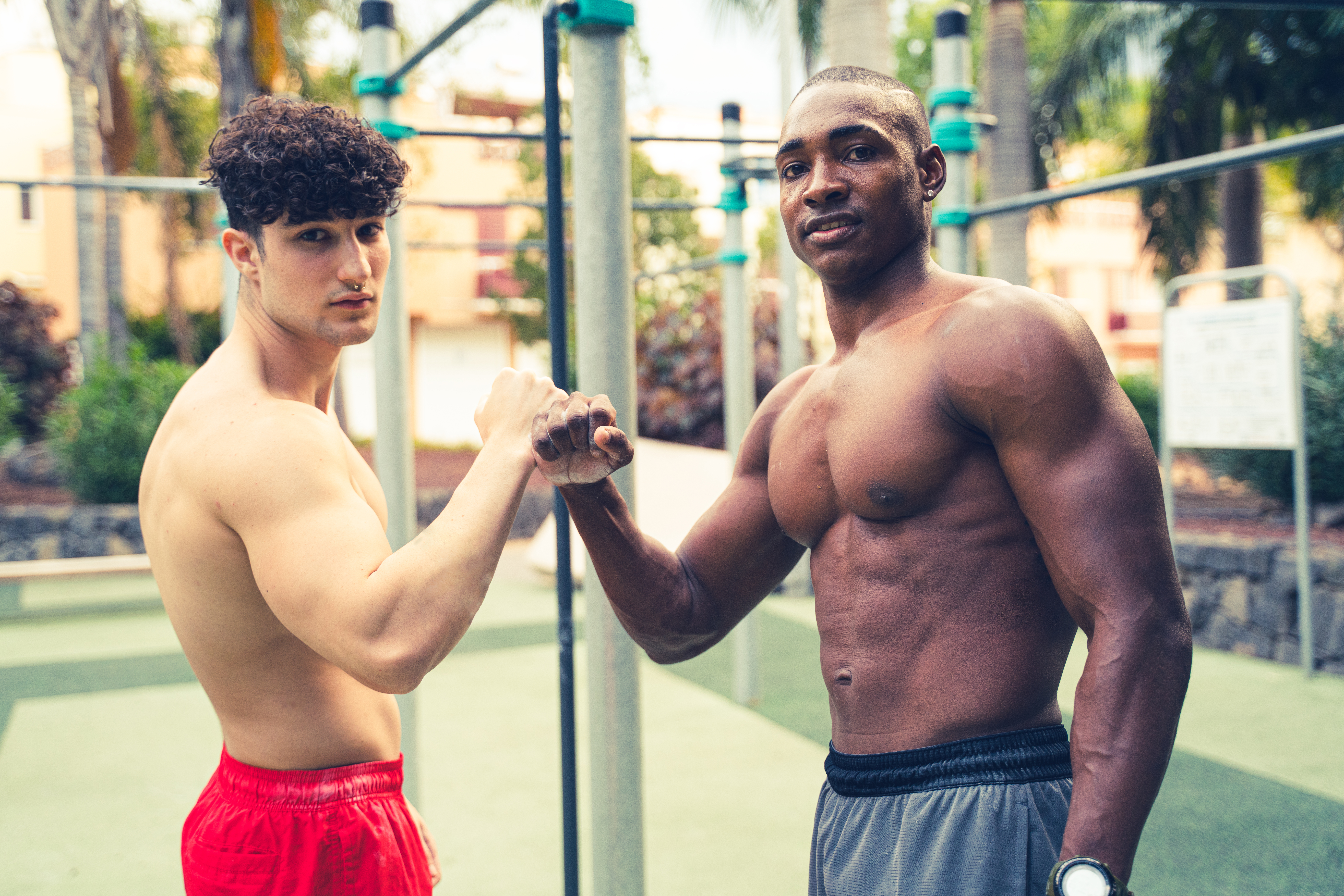 Two young friends after training in open-air calisthenics. Muscular boys after exercising. Outdoor gym. Hobby.