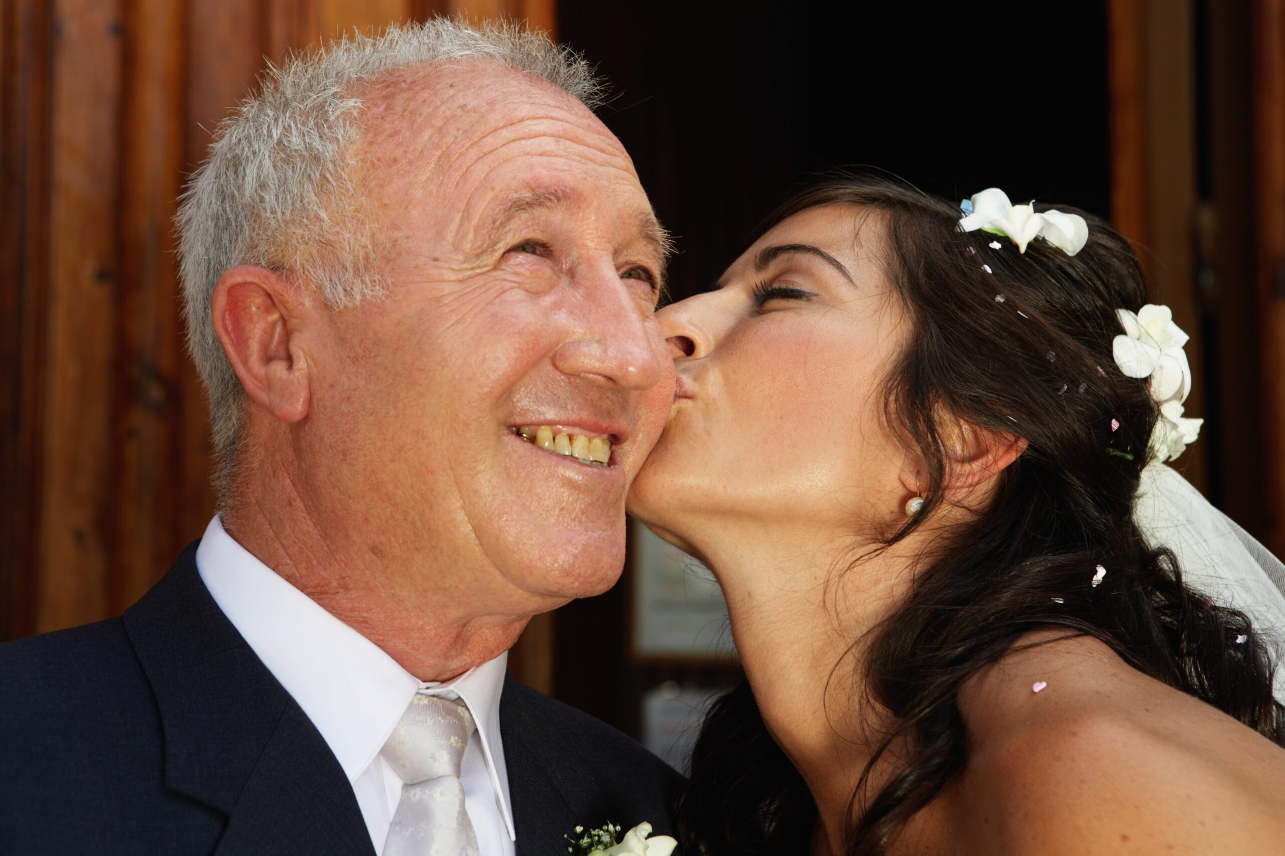 Bride kissing father on cheek, close-up