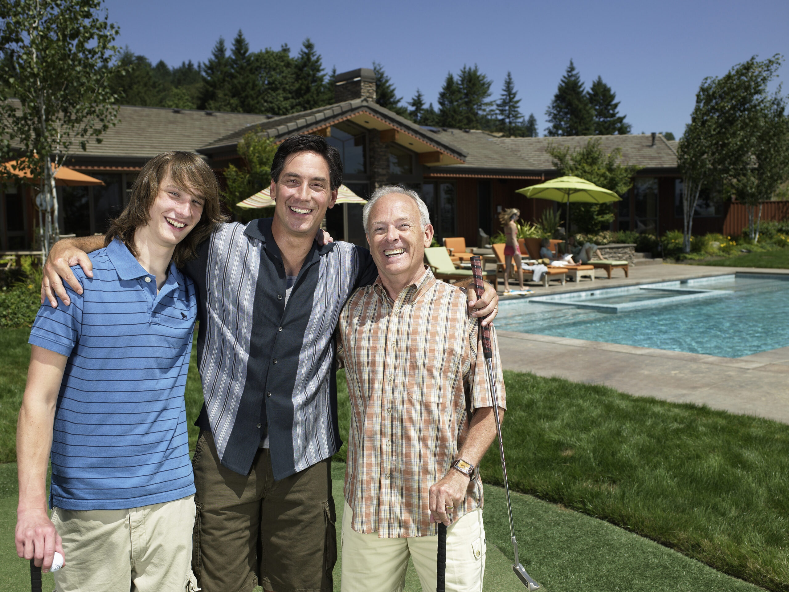 Grandfather, father and grandson with golf club, smiling, portrait