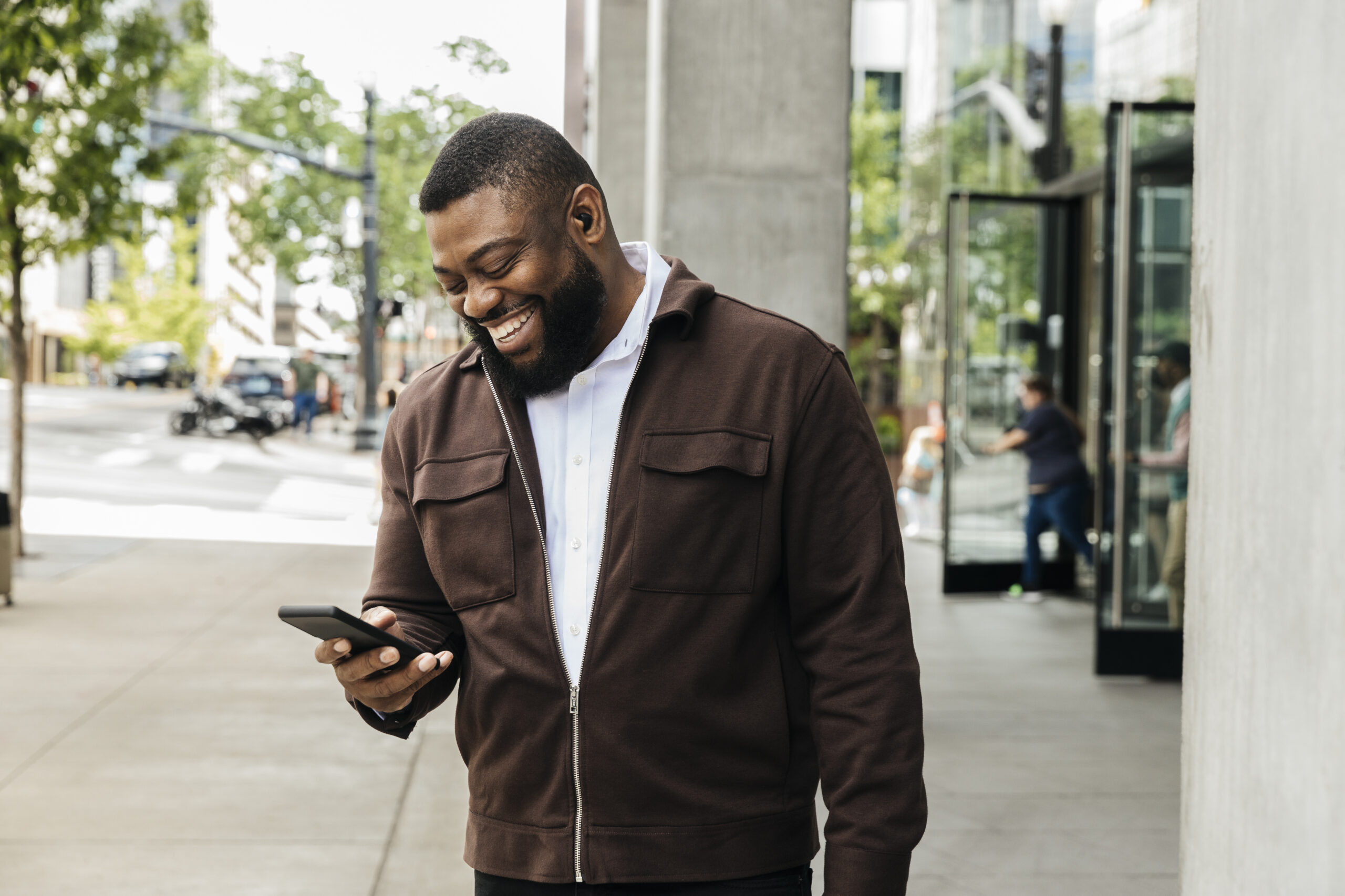 Smiling businessman talking on smart phone on city street
