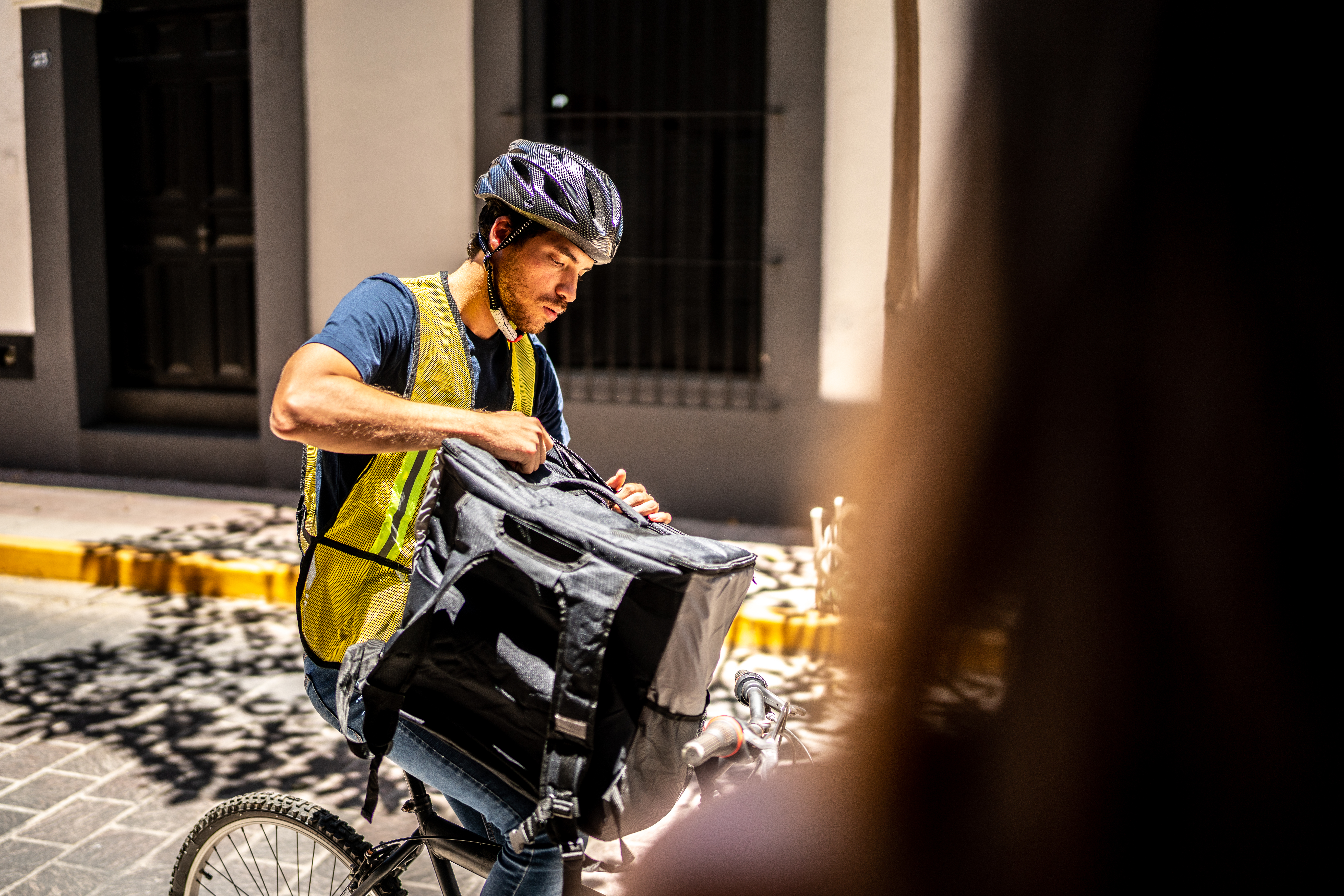 Young bike delivery man talking to customer delivering a package