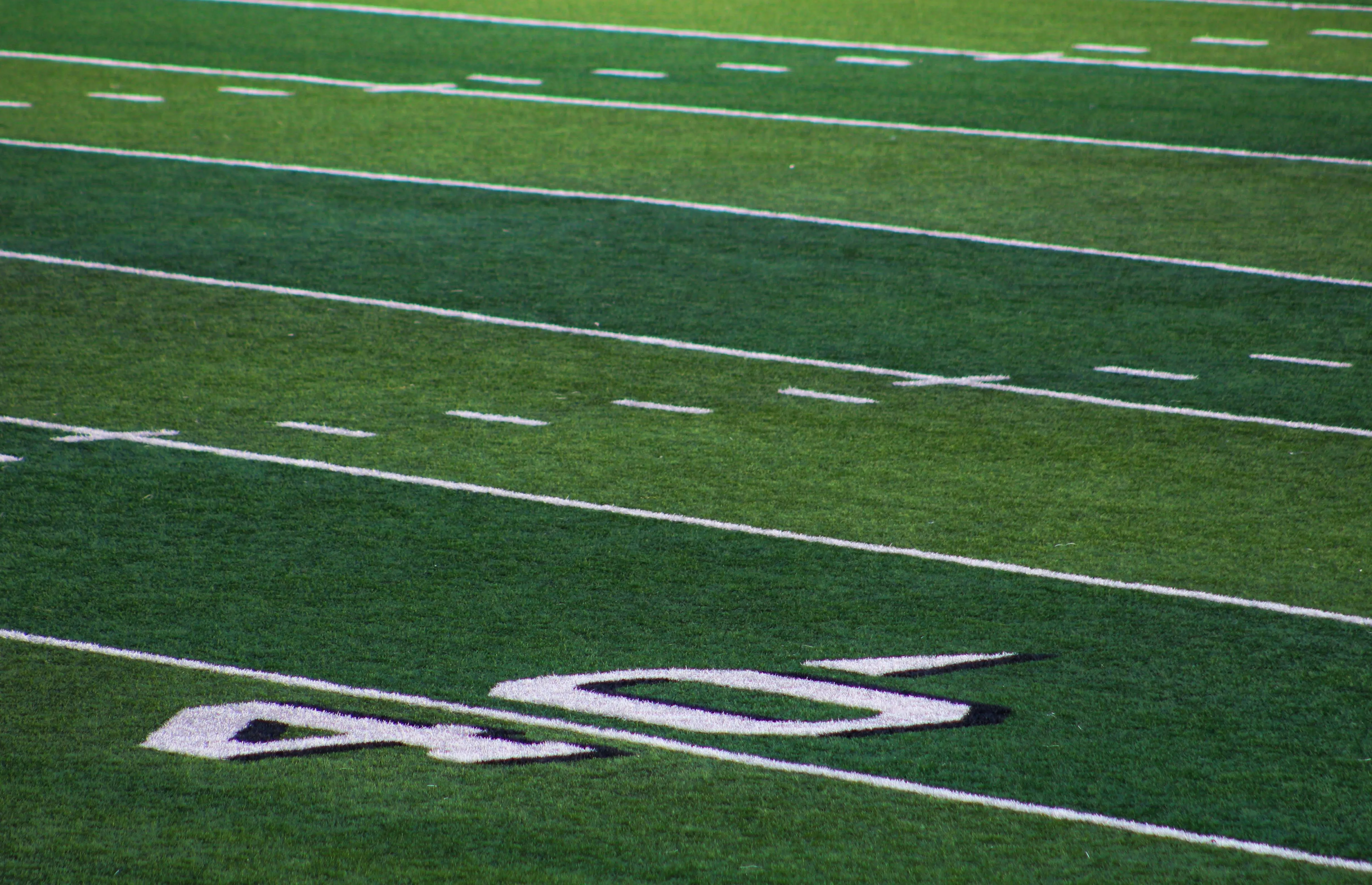 green and white striped football field showing the 40 yard line
